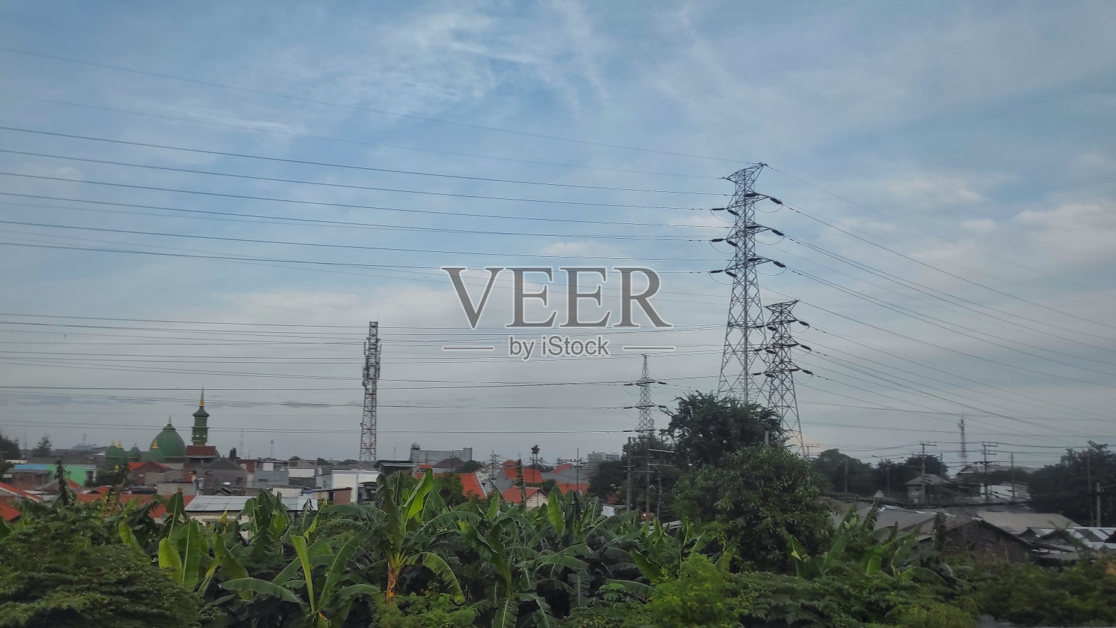 在阳光明媚的日子里，市区有电塔的住宅小区的景观照片摄影图片