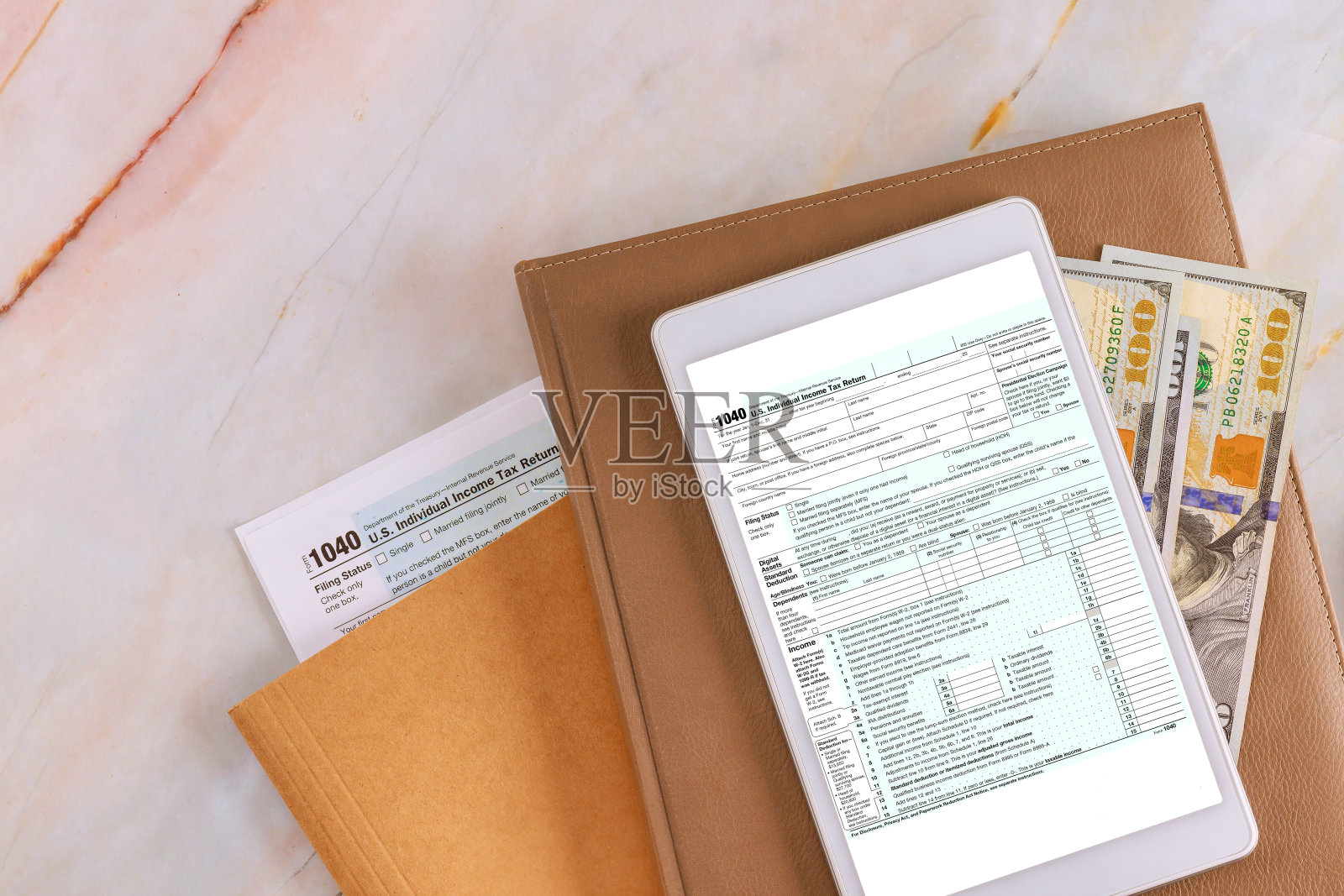 会计办公室准备个人所得税表格1040，以便在纳税季节在电子平板电脑上在线提交照片摄影图片