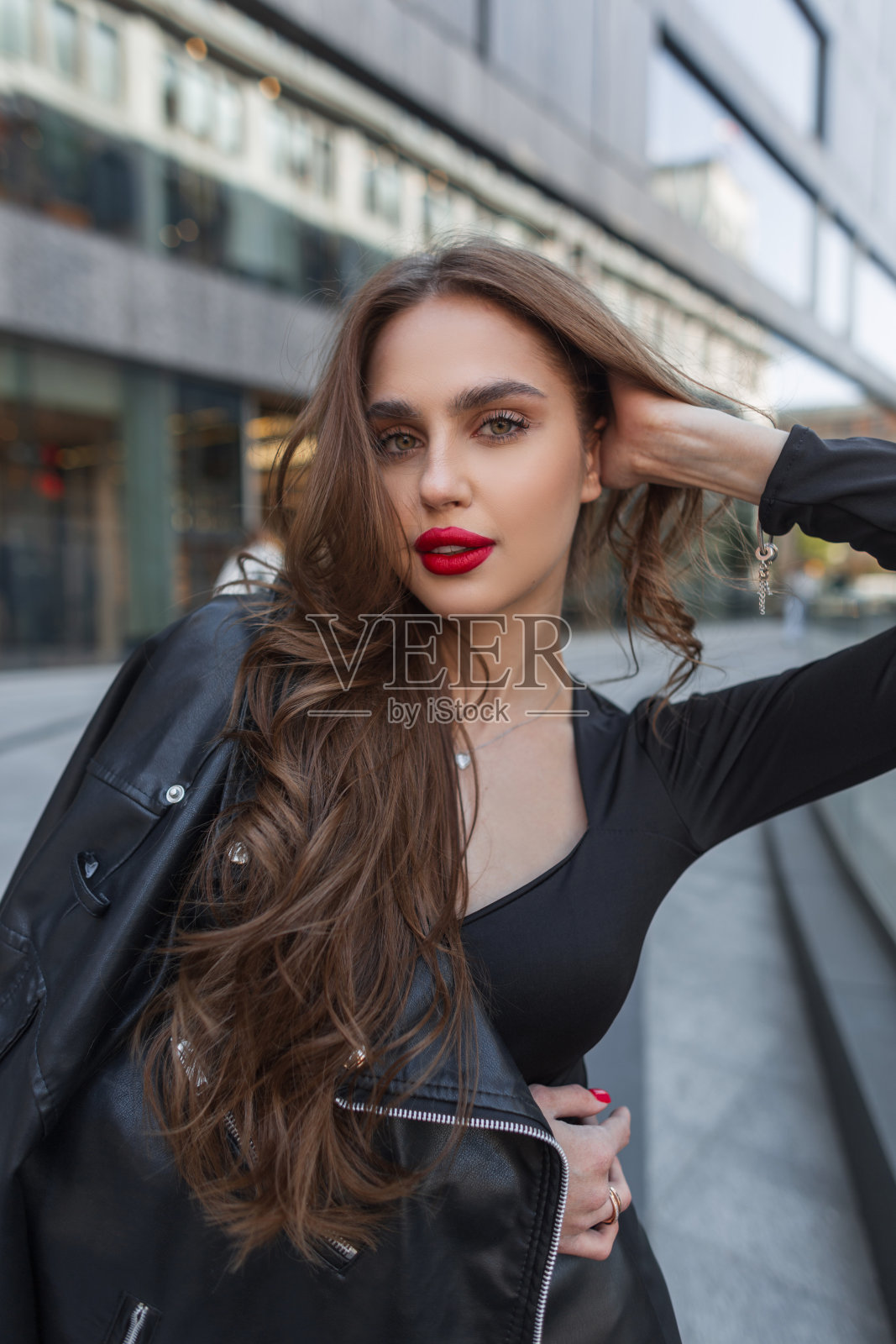 时尚的年轻魅力，漂亮别致的女士，红唇，黑色时尚的衣服，皮夹克走在城市照片摄影图片