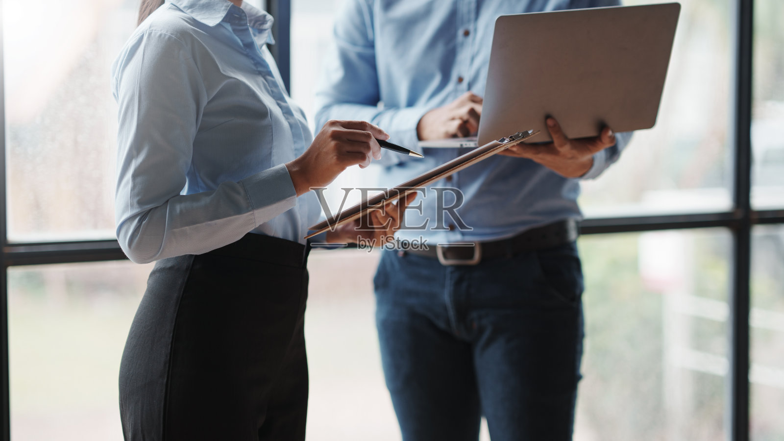 团队商务人员在办公室开会讨论图表并指向图表公司报告分享营销。业务团队站在办公室一起讨论和工作。照片摄影图片