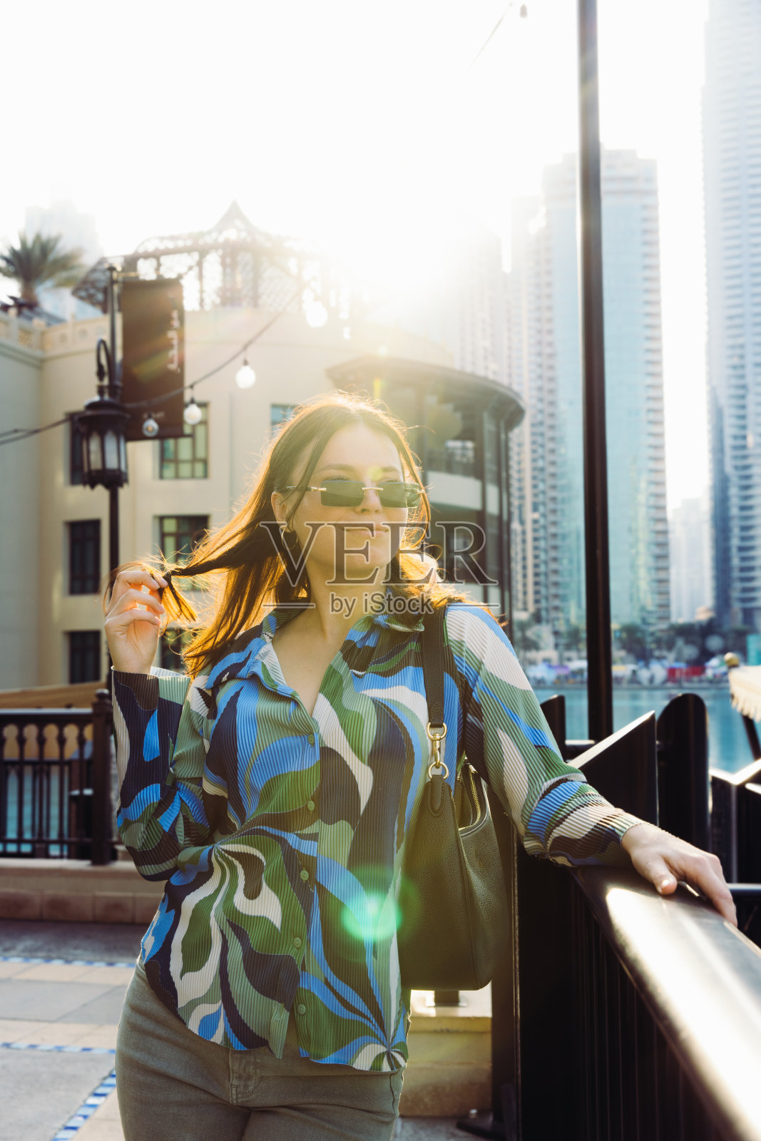 女子欣赏迪拜市中心摩天大楼上的日落美景照片摄影图片