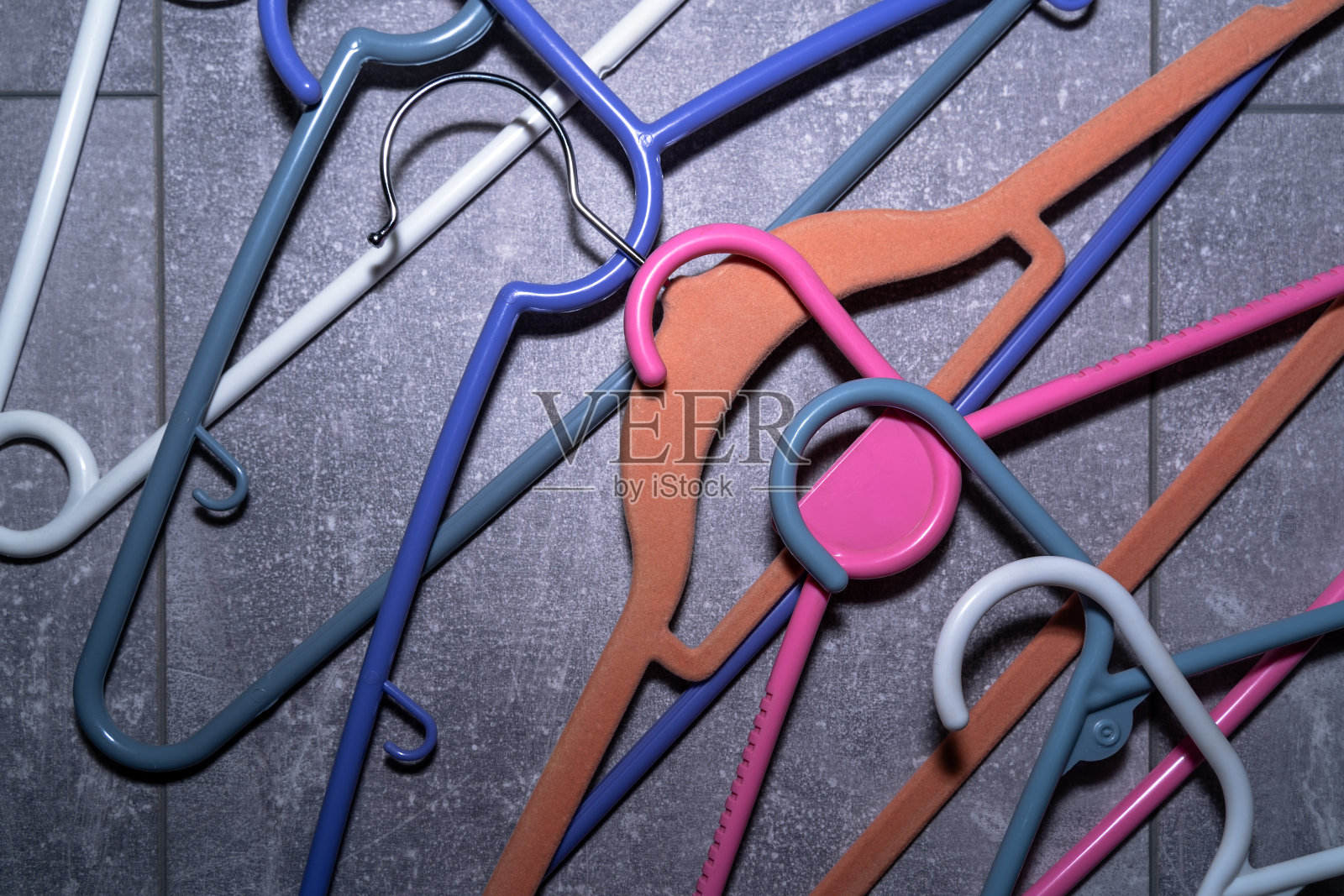 灰色地板上的彩色衣架照片摄影图片