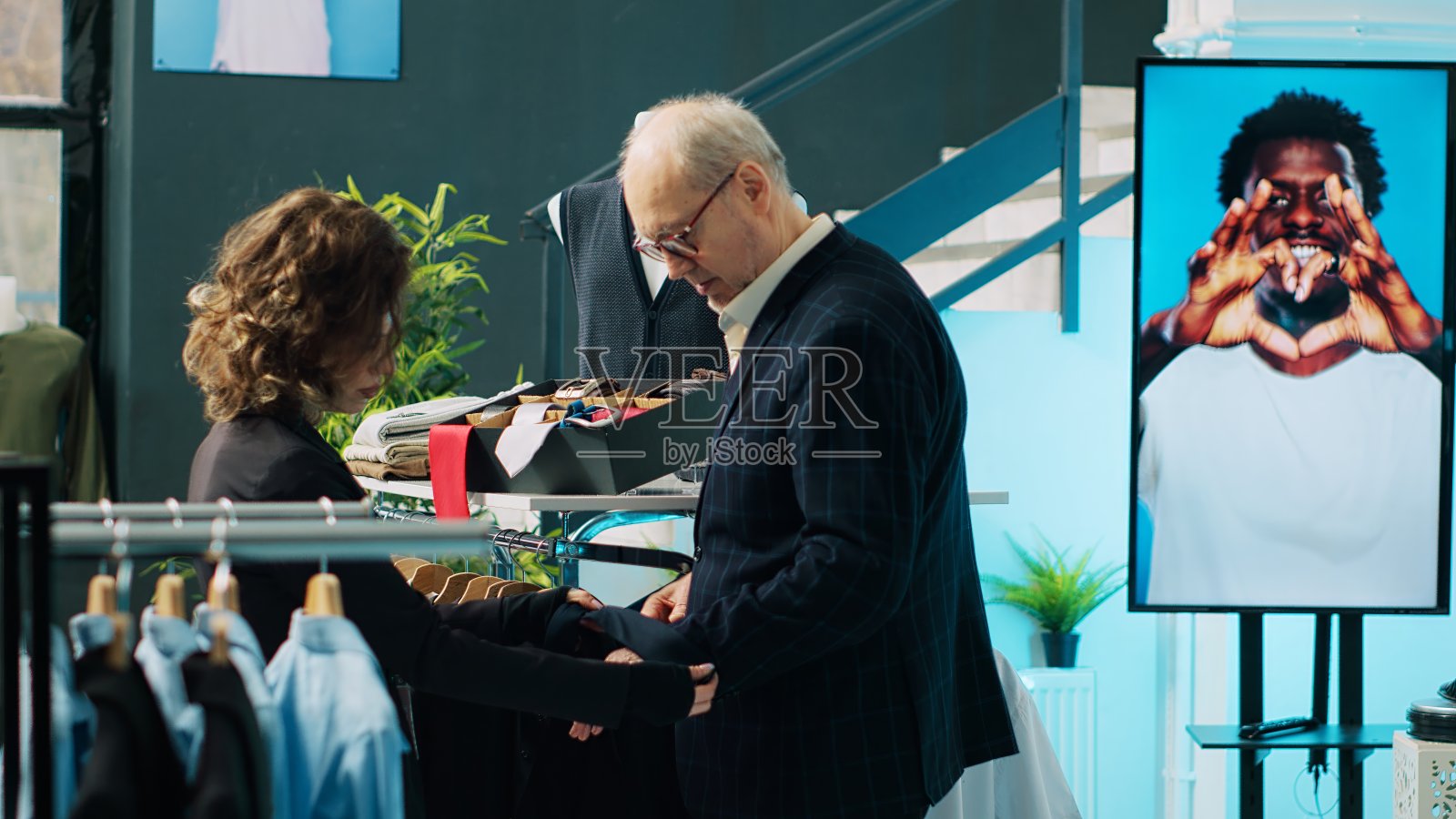 女店员向顾客展示多种颜色的领带照片摄影图片