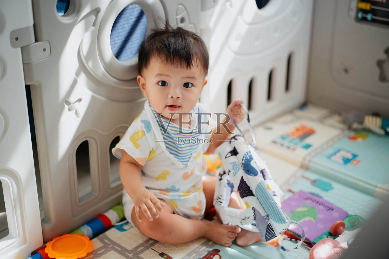 图为一个亚洲小男孩在婴儿游戏垫上玩耍照片摄影图片