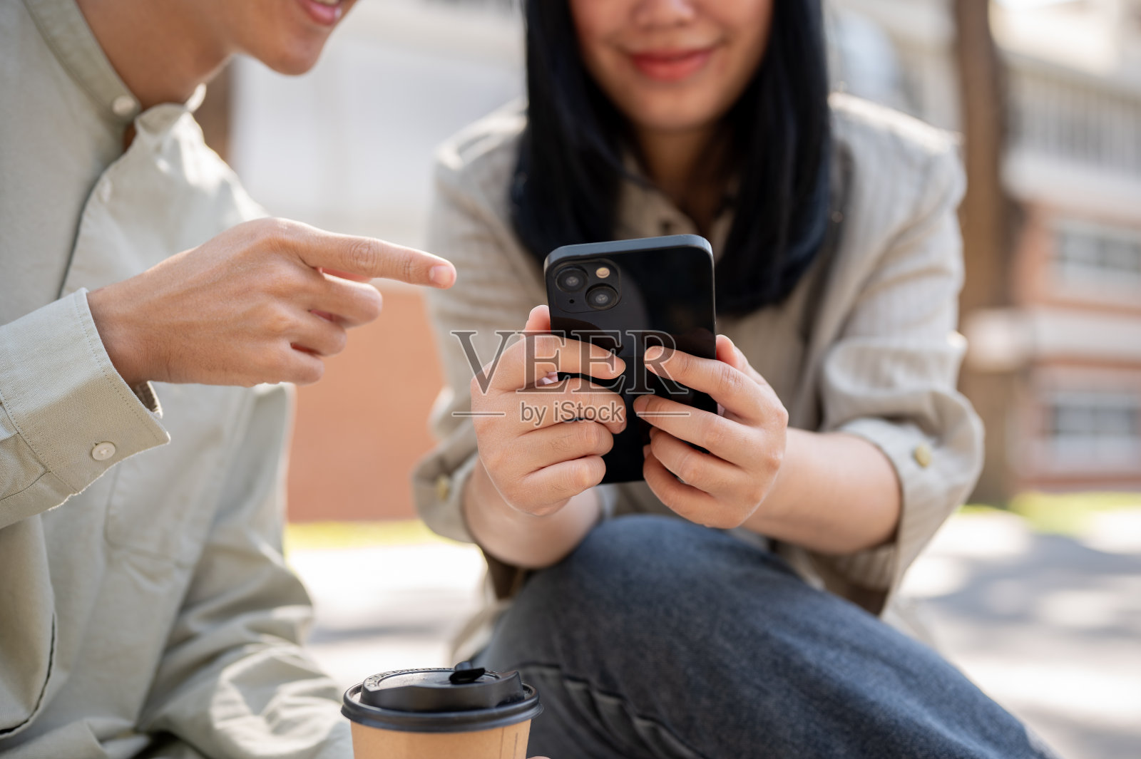 两个朋友在公园里聊天，一起看视频。照片摄影图片