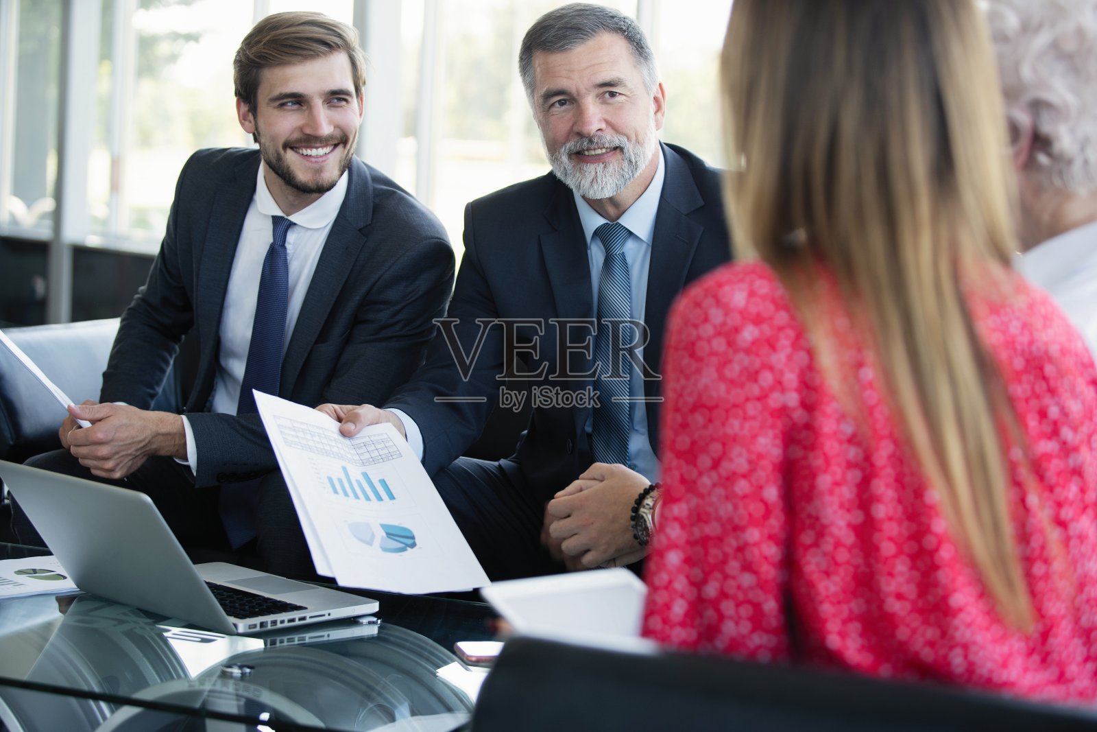 一群穿着正式服装的不同同事在现代办公室的餐桌上讨论商业想法，一起工作。照片摄影图片