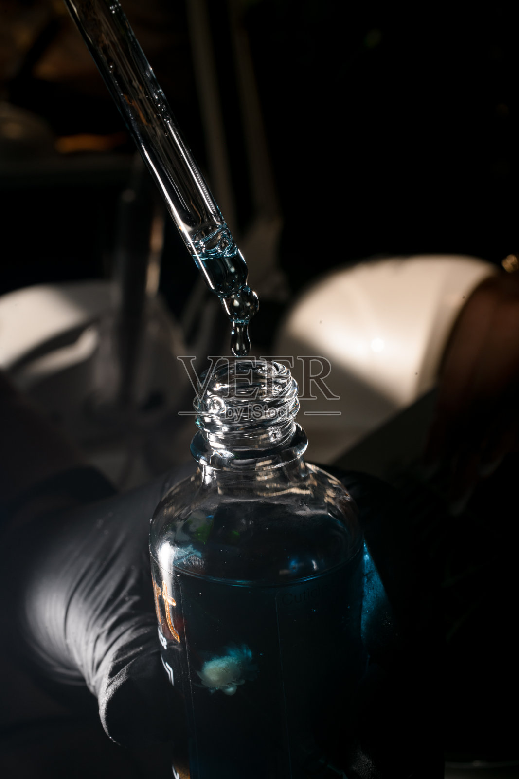 女美甲师的手往滴管里倒保湿手油照片摄影图片