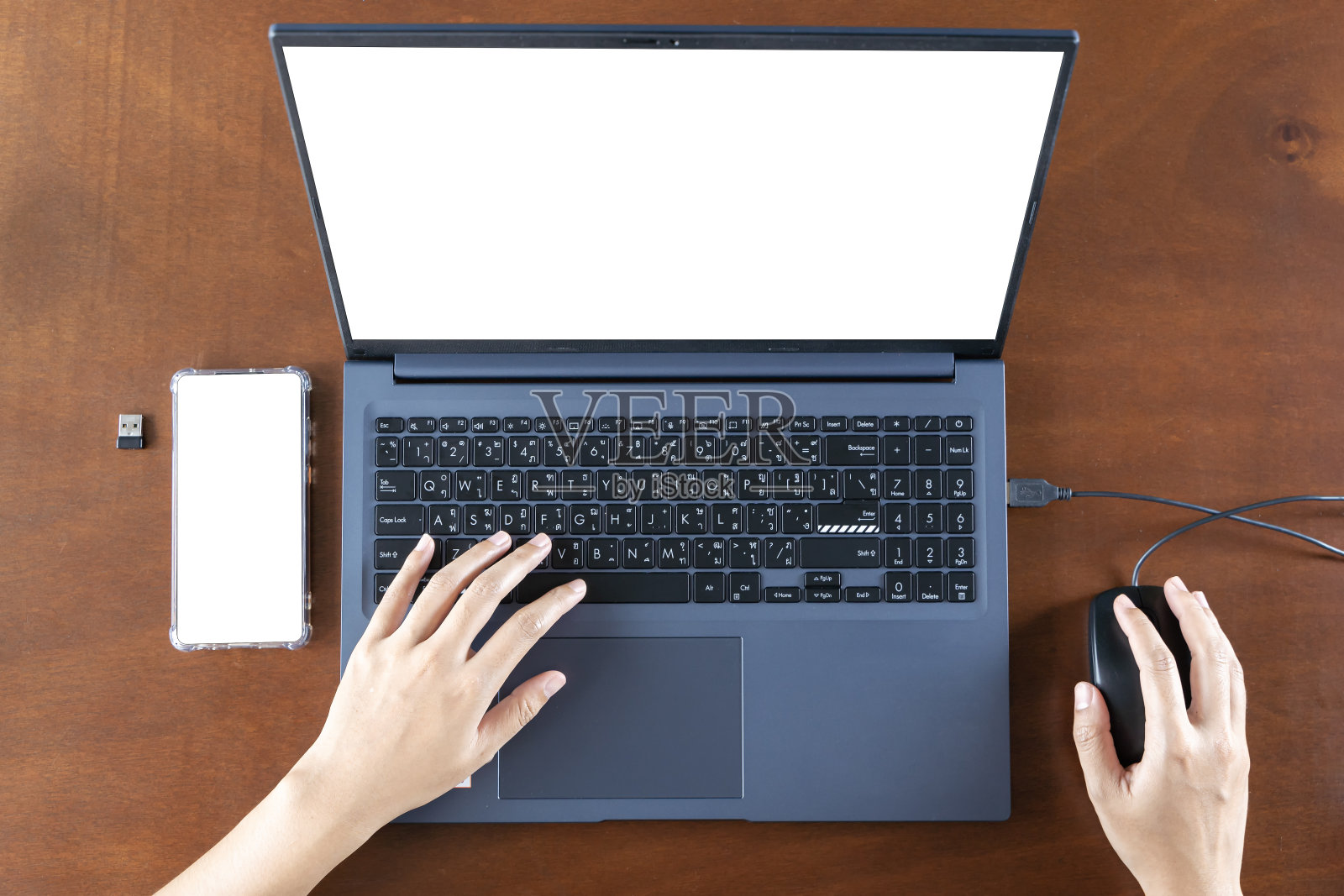 近景:女商人使用智能手机和笔记本电脑，屏幕空白，坐在办公桌前，员工在线咨询客户。照片摄影图片