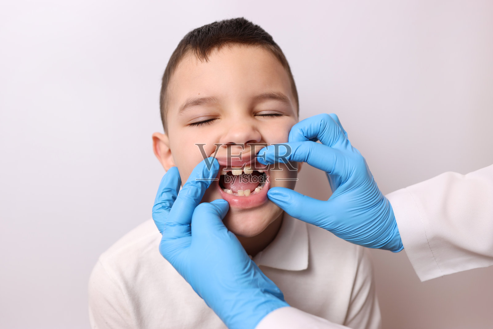 他们检查了一个缺乳牙男孩的口腔。牙科和牙科护理。照片摄影图片