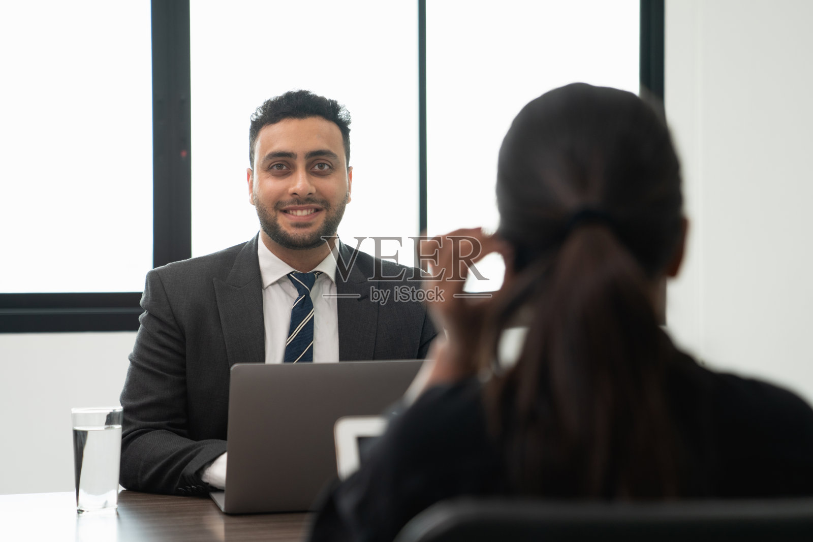 商务人士讨论文件并在笔记本电脑上工作照片摄影图片