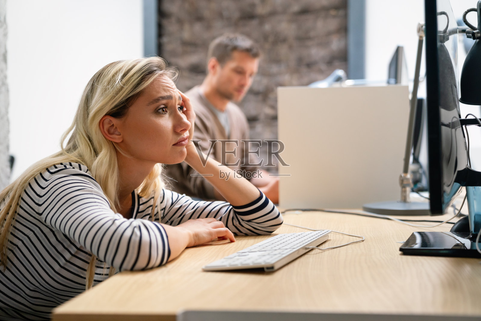 年轻女人因工作疲惫不堪，对着电脑感到无聊沮丧照片摄影图片