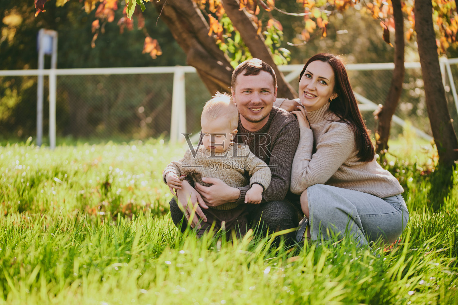 幸福的家庭，妈妈，爸爸和儿子在阳光明媚的日子里在秋天的公园里玩得很开心。爱和忠诚，年轻的父母照片摄影图片