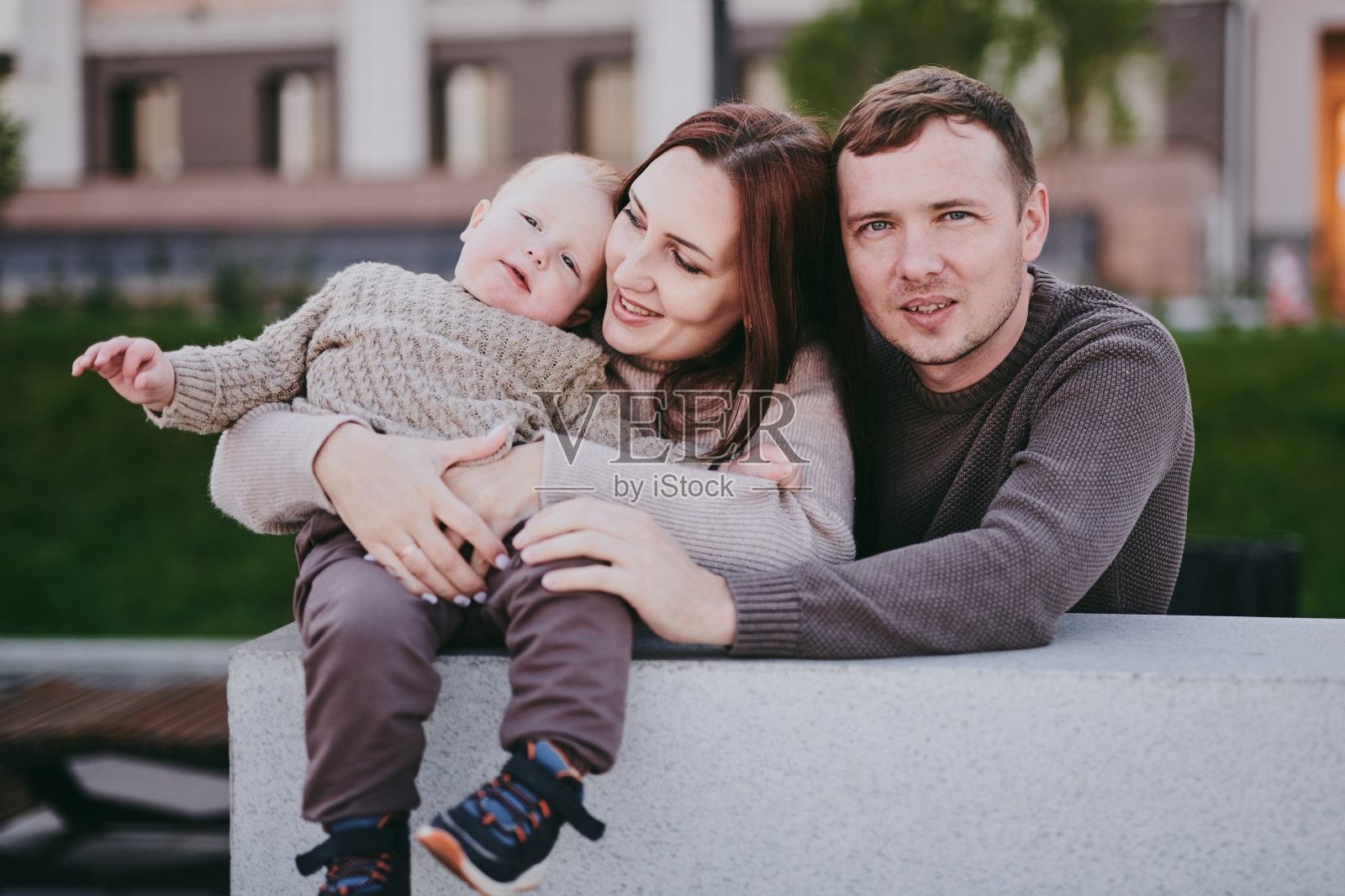 幸福的家庭，妈妈，爸爸和儿子在城市里散步，在阳光明媚的日子里玩得很开心，享受在一起的时光照片摄影图片