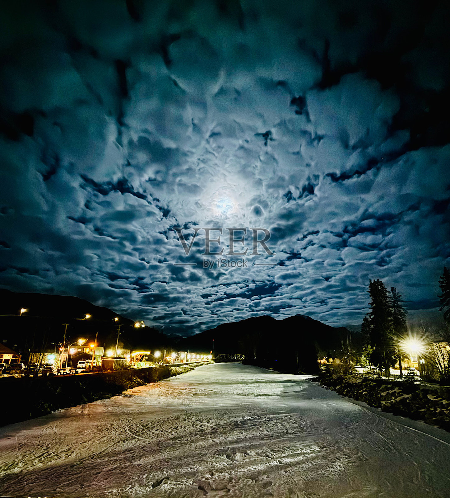 一轮满月照亮了云朵。照片摄影图片