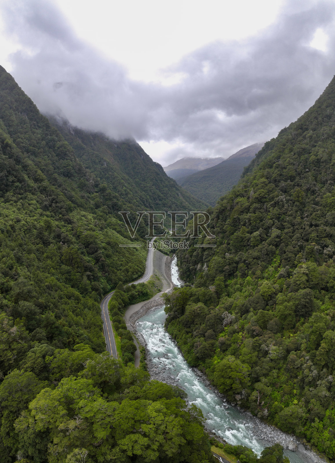 道路穿过温带雨林和咆哮的河流在新西兰照片摄影图片