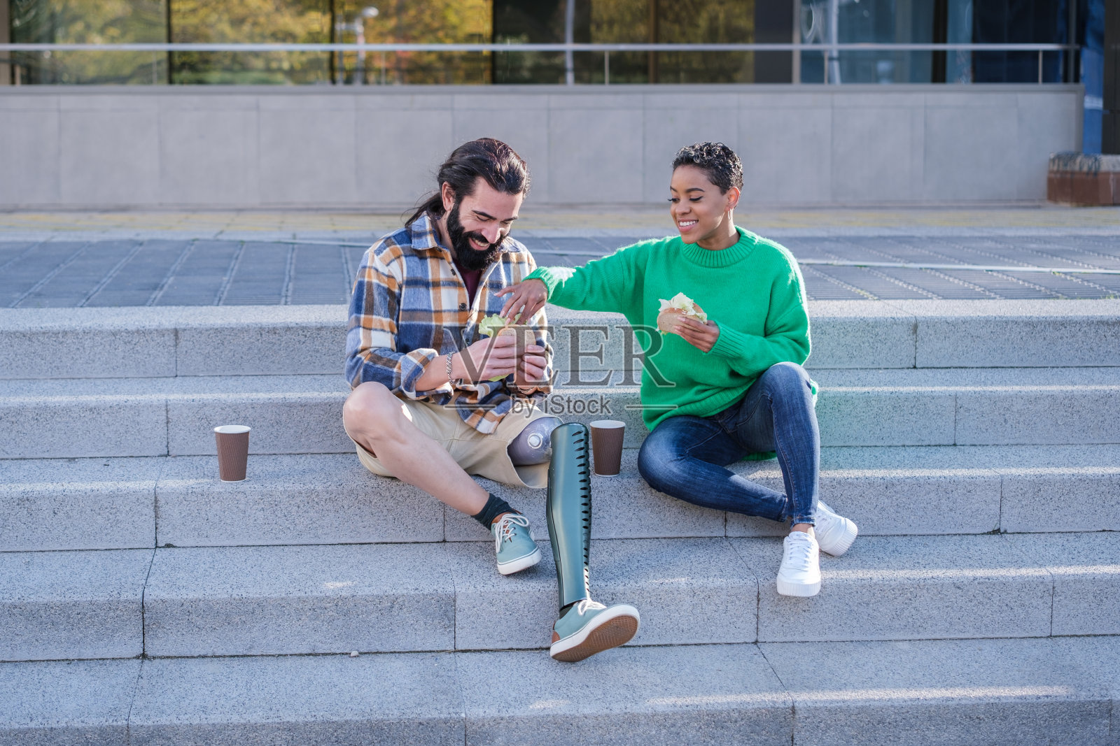 短发女人和戴着假腿的长发男人在户外共度时光照片摄影图片