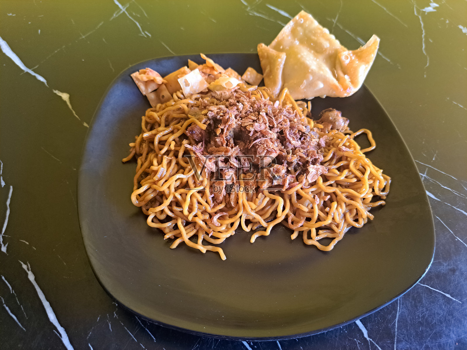 美味的炒面或米羹配鸡肉，煎饺子和炒洋葱。炒饭。食品菜单。照片摄影图片