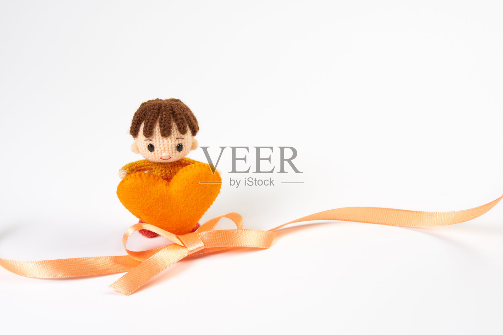 小而可爱的Amigurumi娃娃在白色的背景。日本的橙带运动照片摄影图片