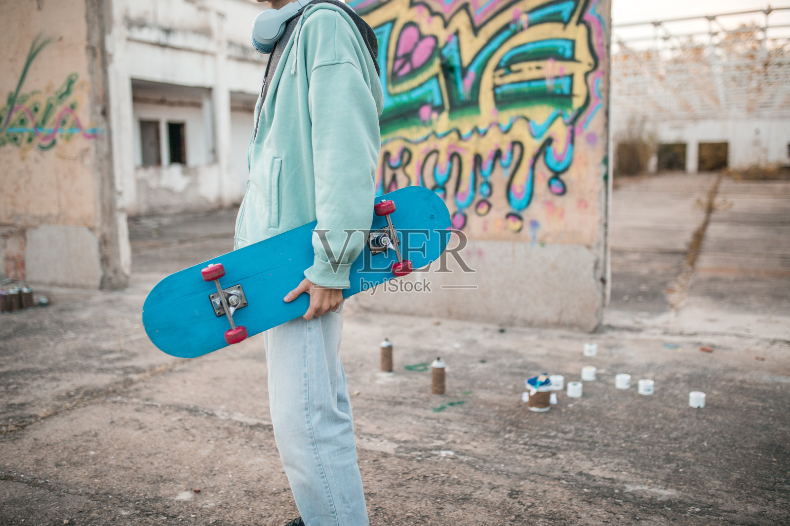 一位无法辨认的男性艺术家站在他涂鸦的墙上照片摄影图片