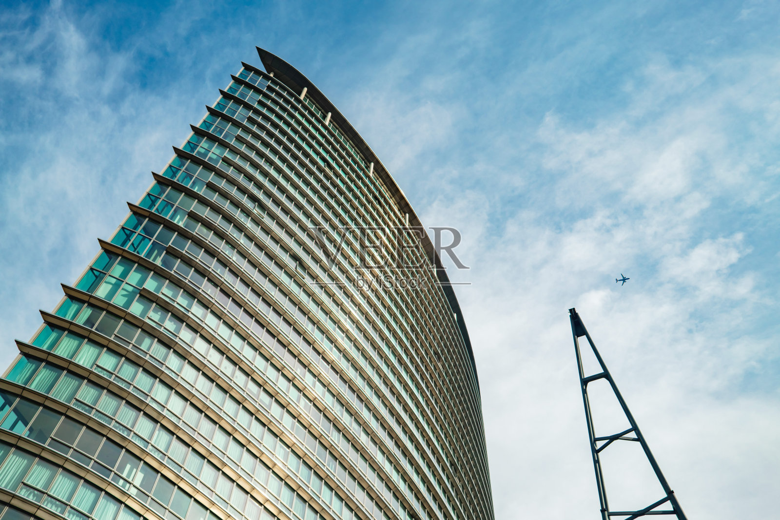 运河岸边的一座现代摩天大楼照片摄影图片