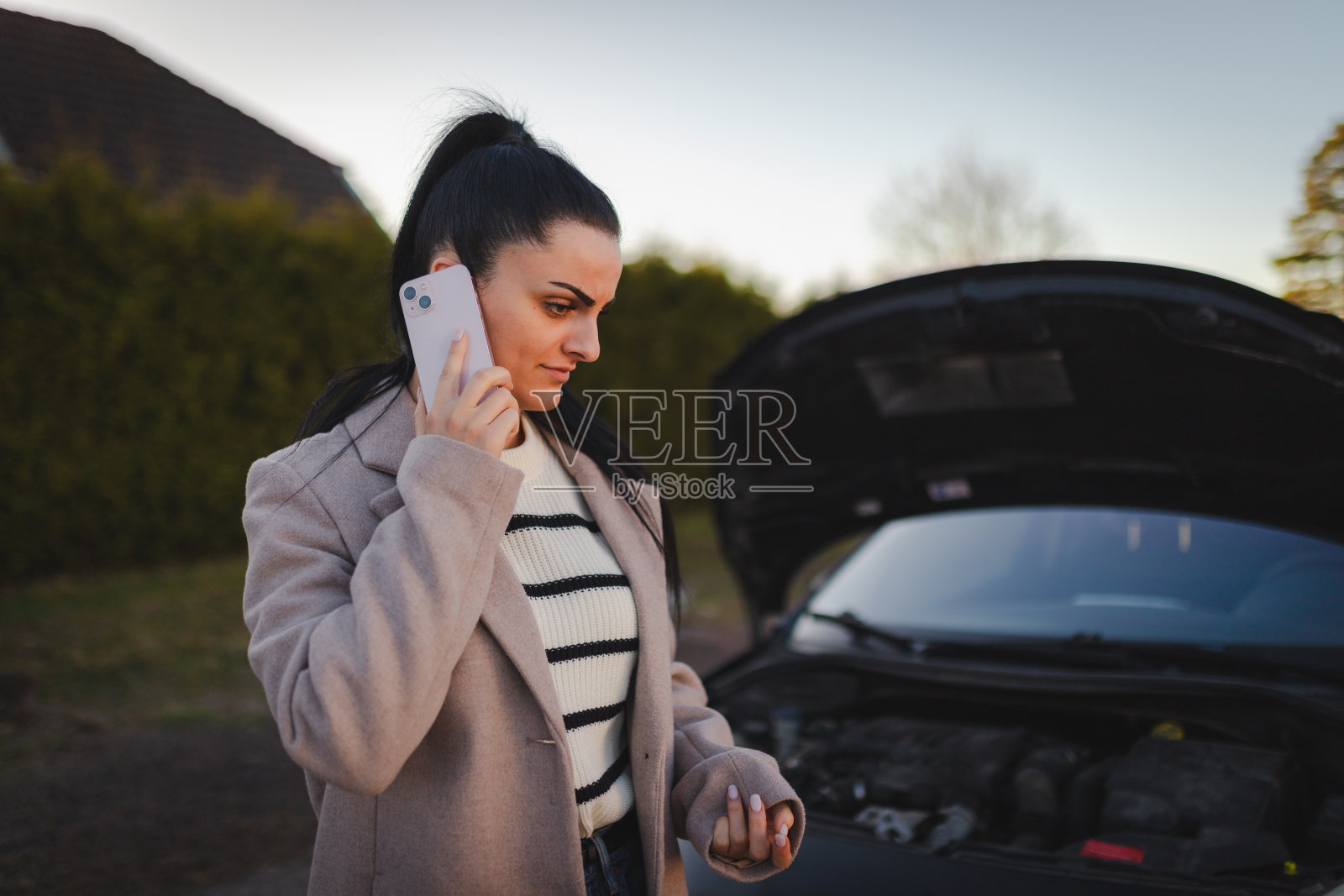 美女打电话求救，因为她的车坏了照片摄影图片