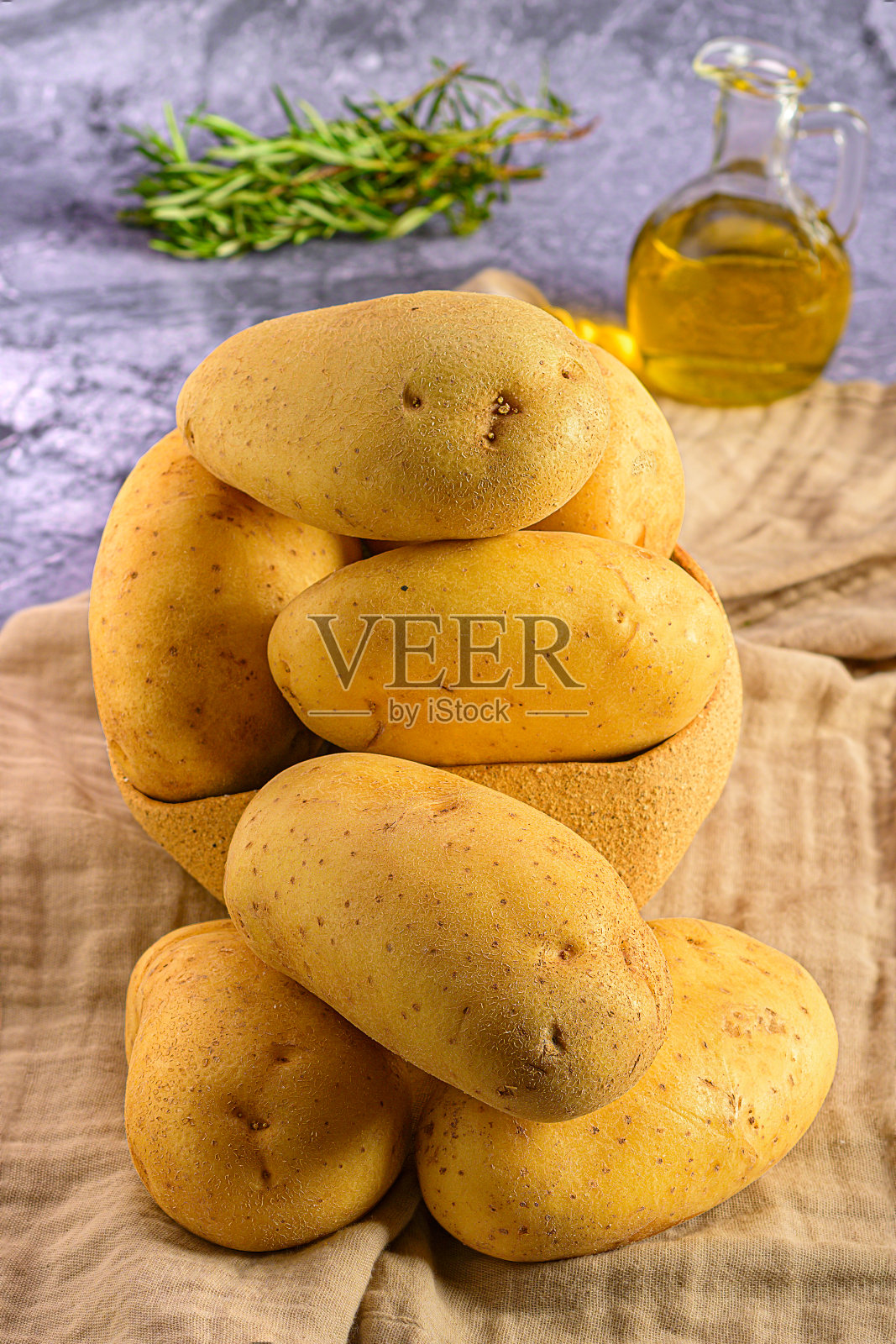 把一堆土豆放在桌子上，洒上橄榄油照片摄影图片
