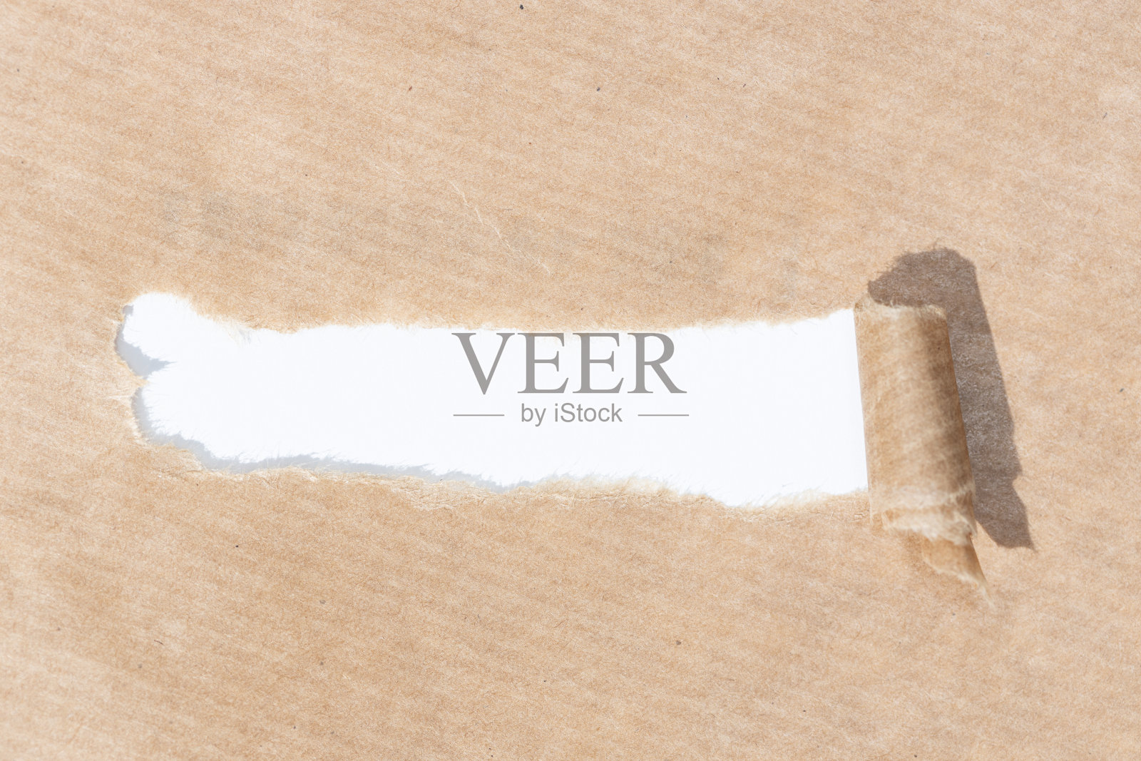 在白纸的背景上，用带撕裂条纹的牛皮纸插入文字照片摄影图片