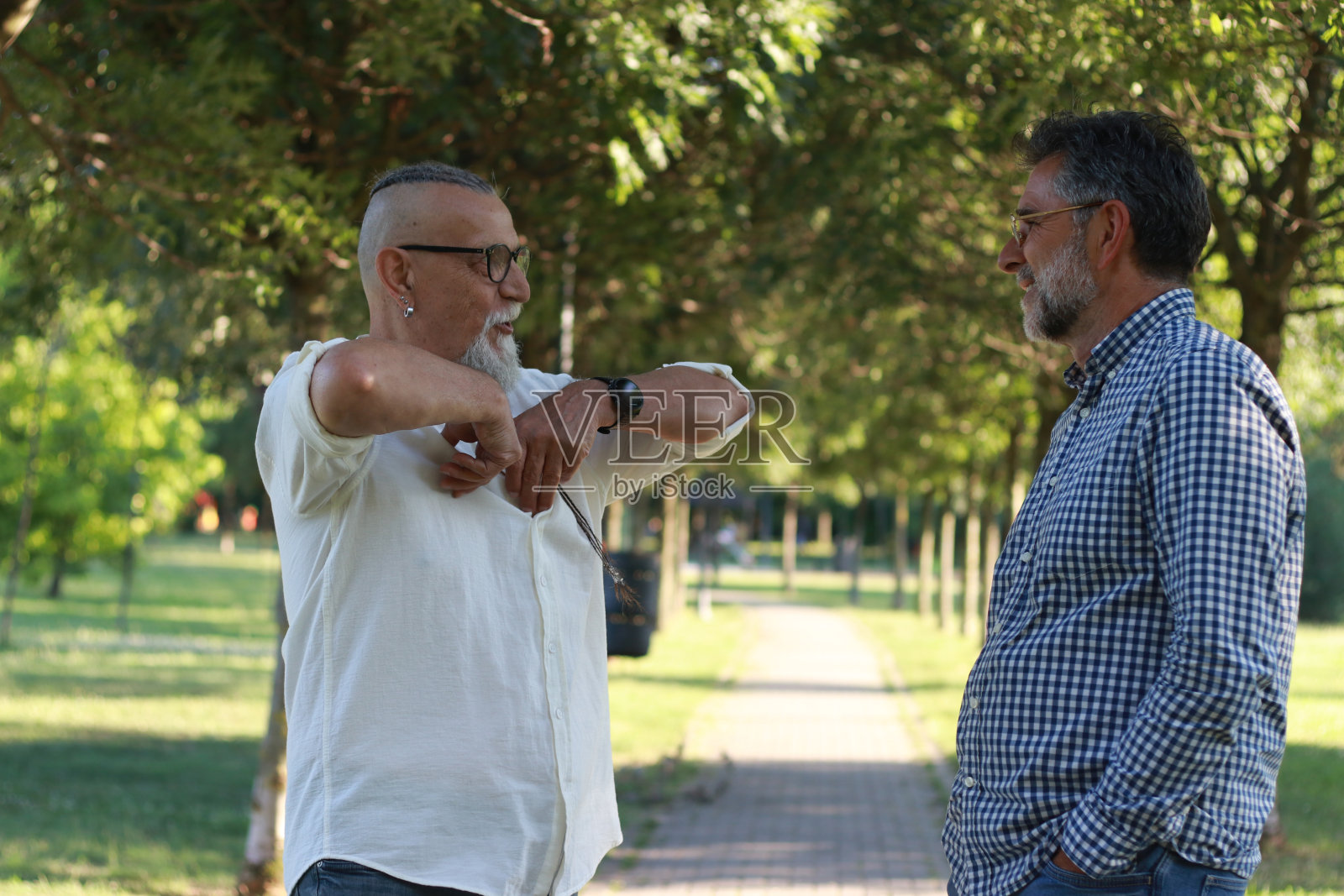 两个老人在公园里散步聊天照片摄影图片