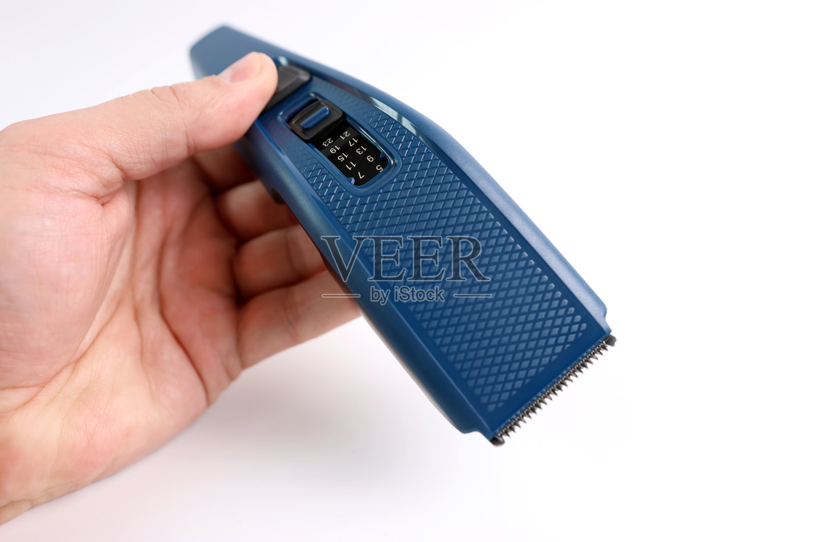 一个男人熟悉了理发器的功能和能力。照片摄影图片