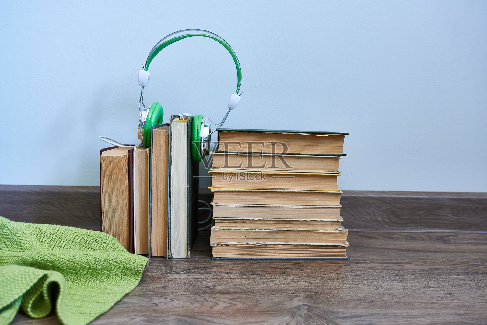 书和耳机放在木地板上。照片摄影图片