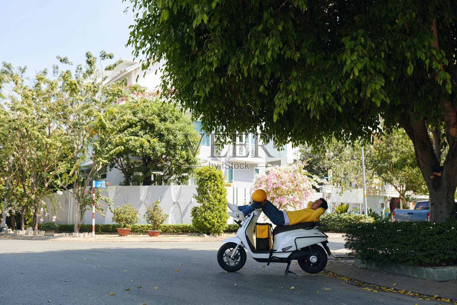 快递员在摩托车上放松照片摄影图片