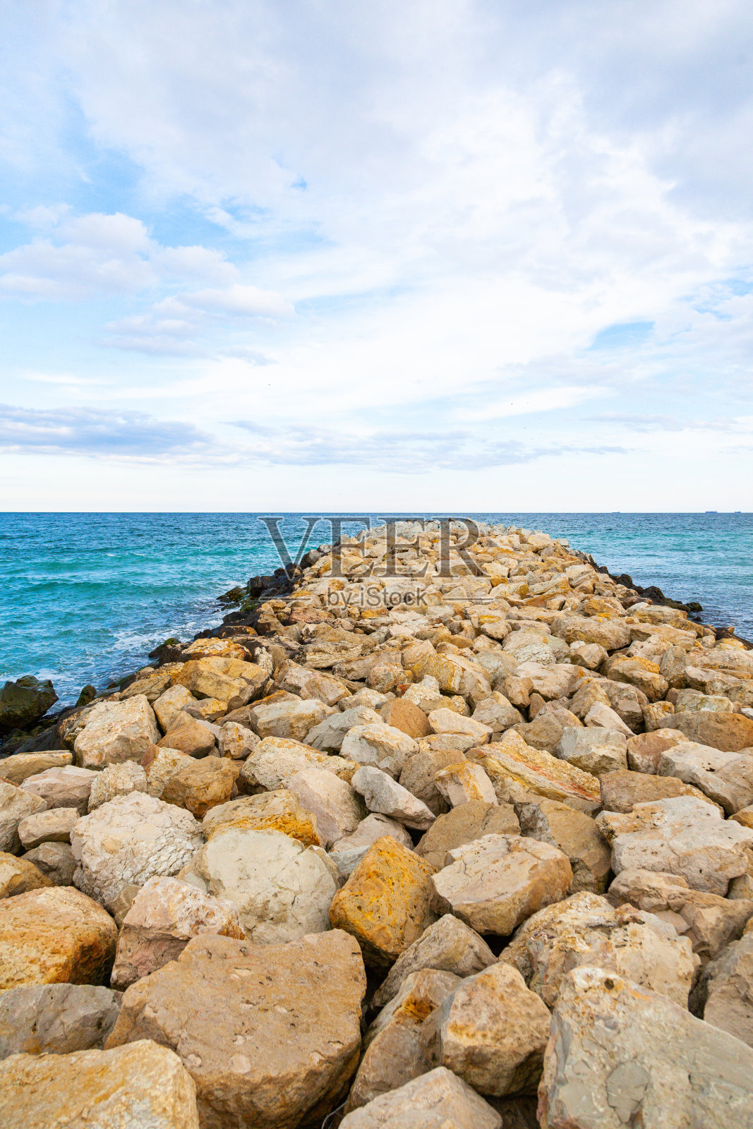 海中安装了由天然大石块制成的防波堤。照片摄影图片