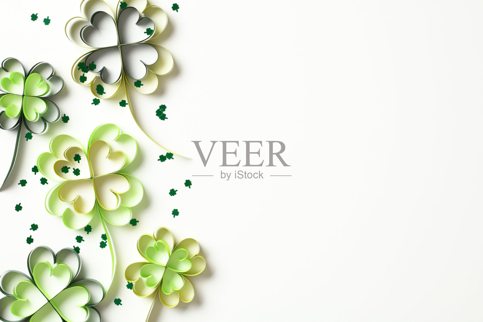 圣帕特里克节的俯视图照片，剪纸苜蓿叶和白色背景的纸屑。照片摄影图片