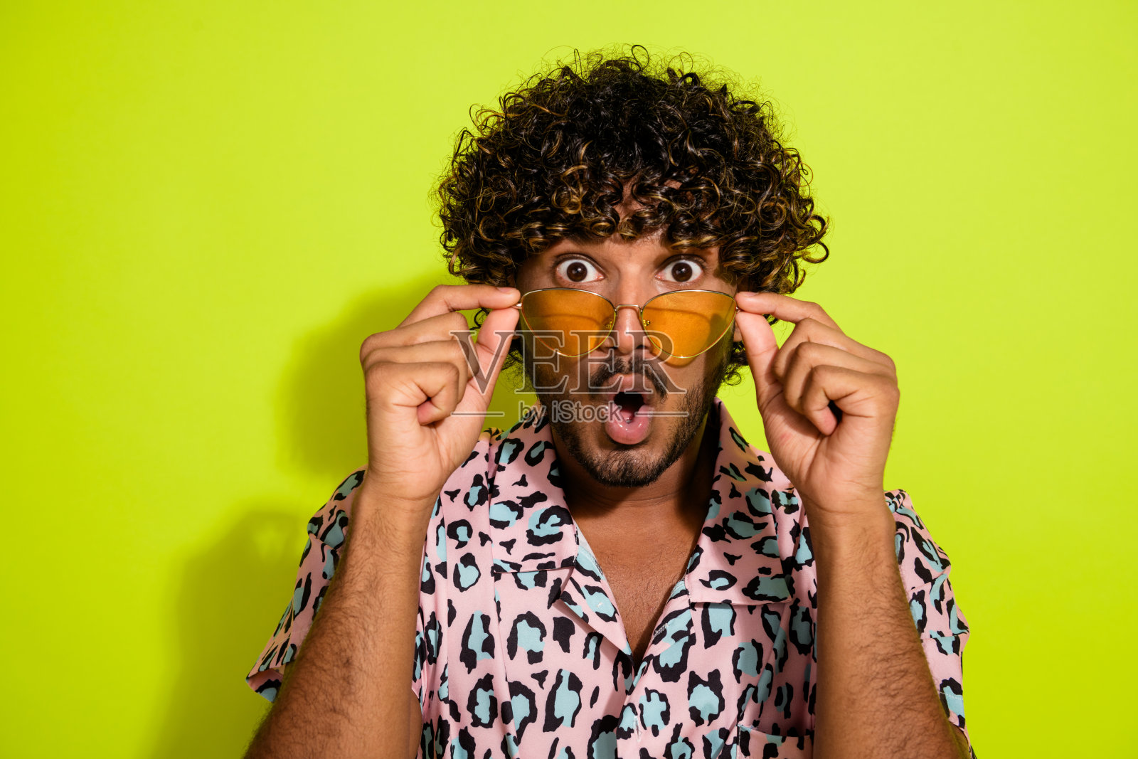 漂亮的年轻男性的照片肖像张开嘴惊讶地穿着时髦的粉红色豹纹服装孤立在黄色背景照片摄影图片