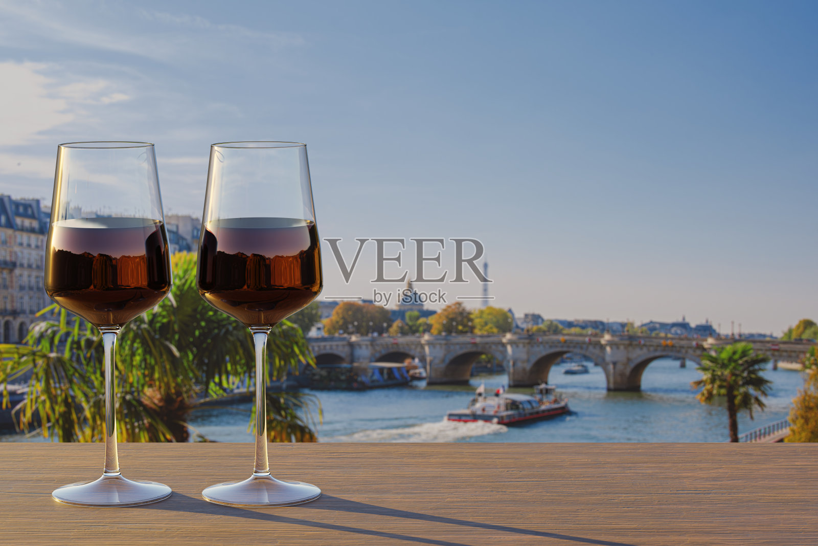 在巴黎塞纳河畔的浪漫之夜，两杯红酒，在日落时分欣赏标志性的埃菲尔铁塔，在宁静的塞纳河上投下温暖的光芒。照片摄影图片