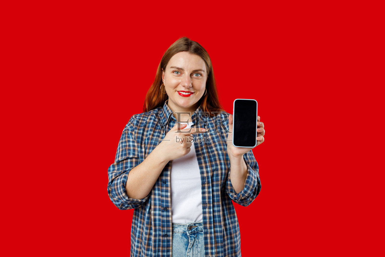 伟大的移动报价。兴奋快乐的30岁女性用手指着手中的智能手机，对新应用程序做出情绪化的反应照片摄影图片