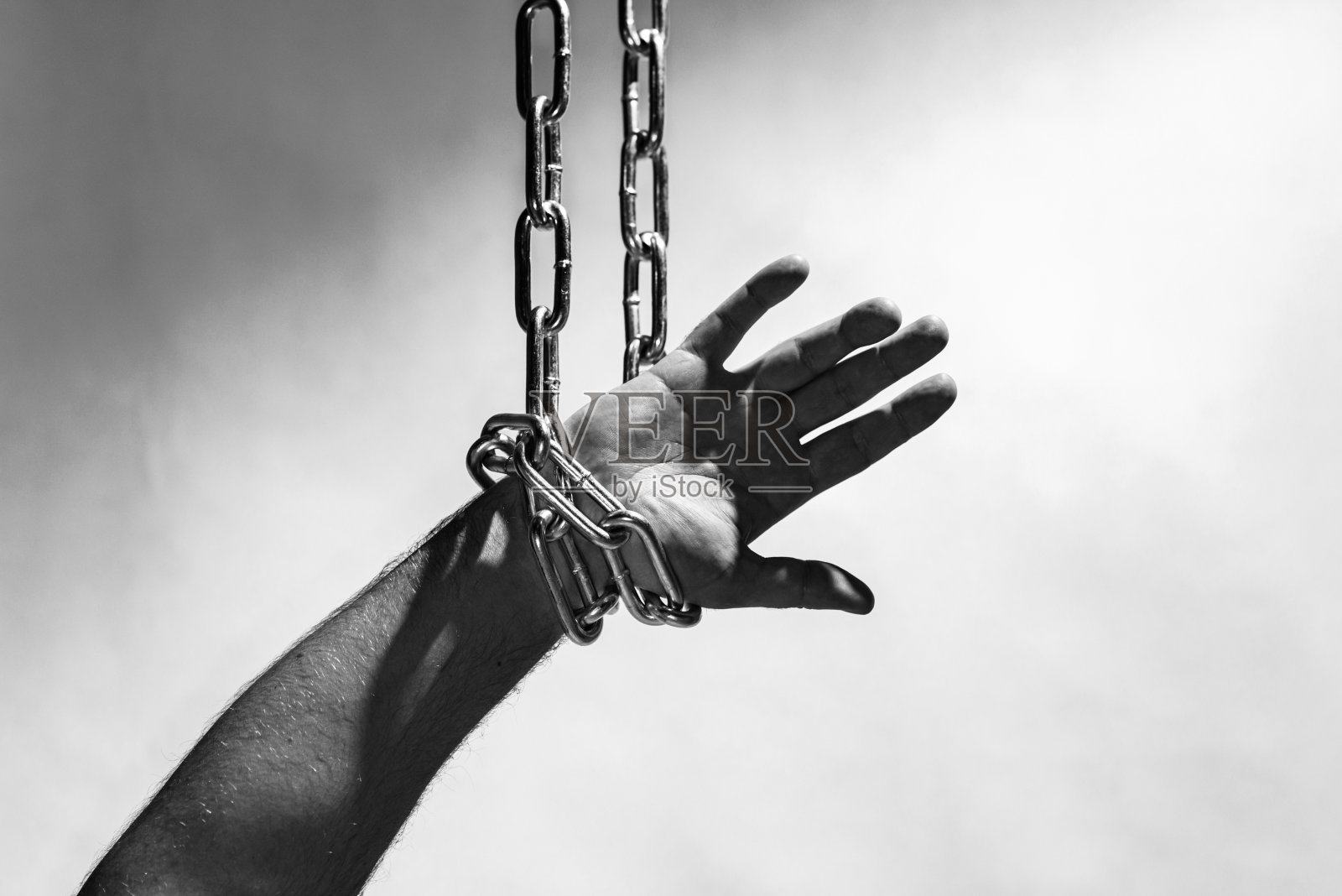 手带链挂，链在手，链缠绕在手，灰色背景。副本的空间。照片摄影图片