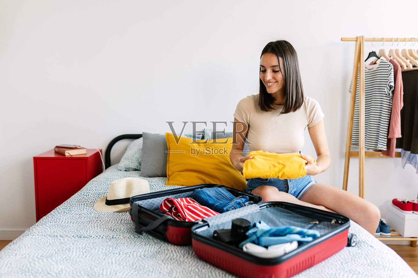 快乐的女人在为暑假旅行打包行李照片摄影图片