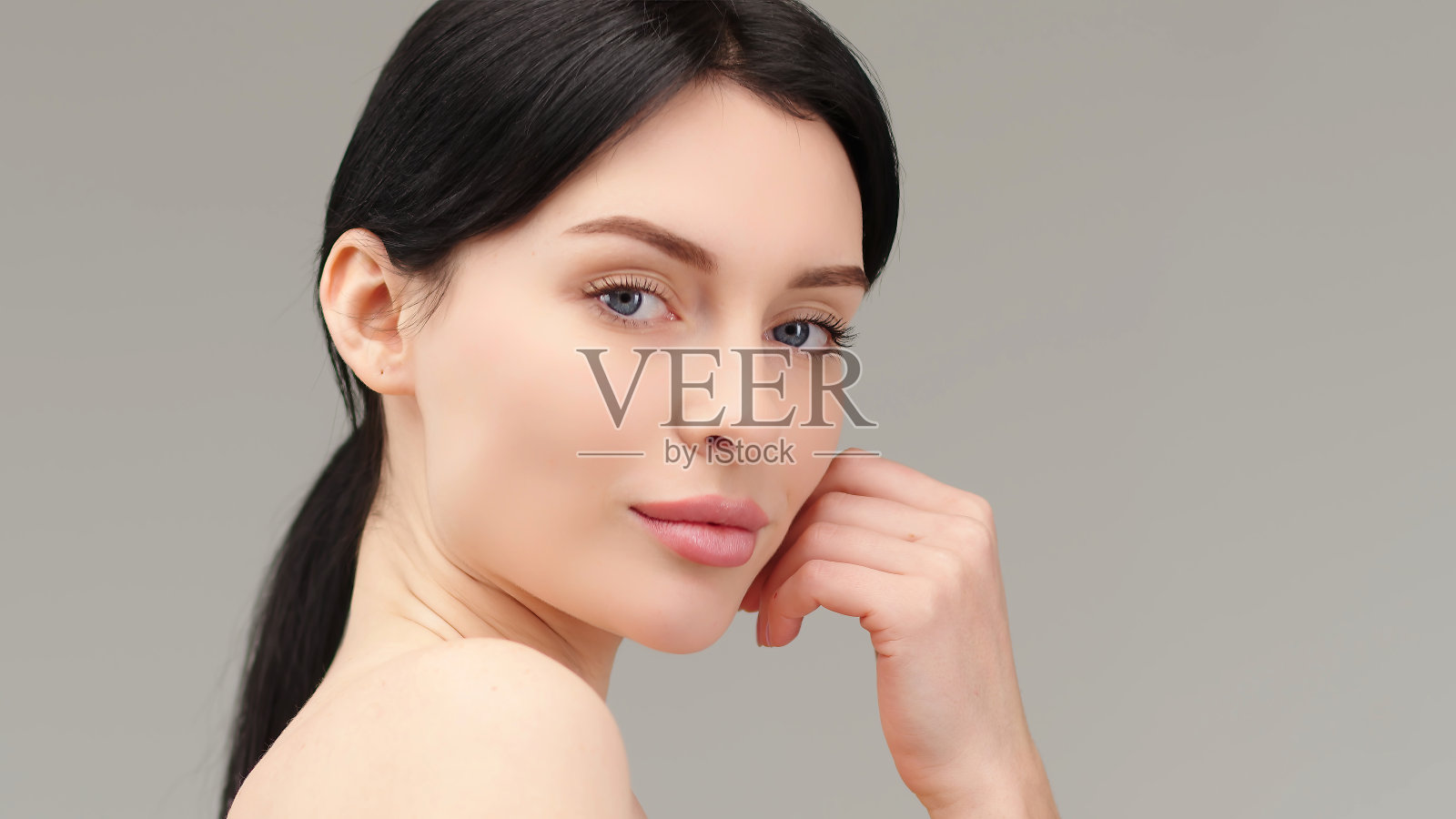 一个年轻女子在浅色背景上被孤立的肖像。皮肤护理。美丽的女模特，完美清洁的新鲜皮肤。自然美和美容概念照片摄影图片