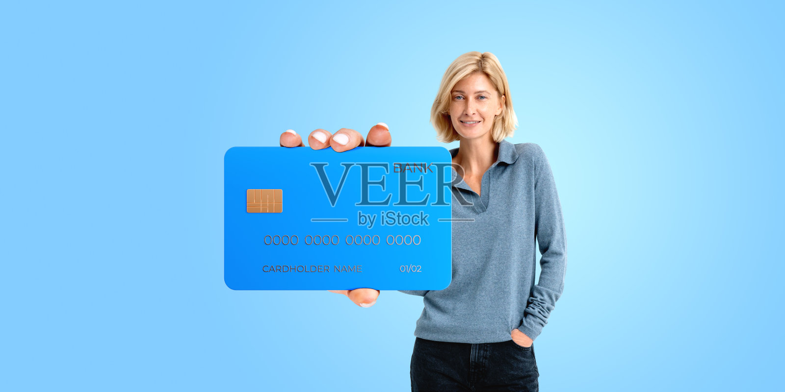 快乐的女人拿着一张宽幅蓝色背景的信用卡照片摄影图片