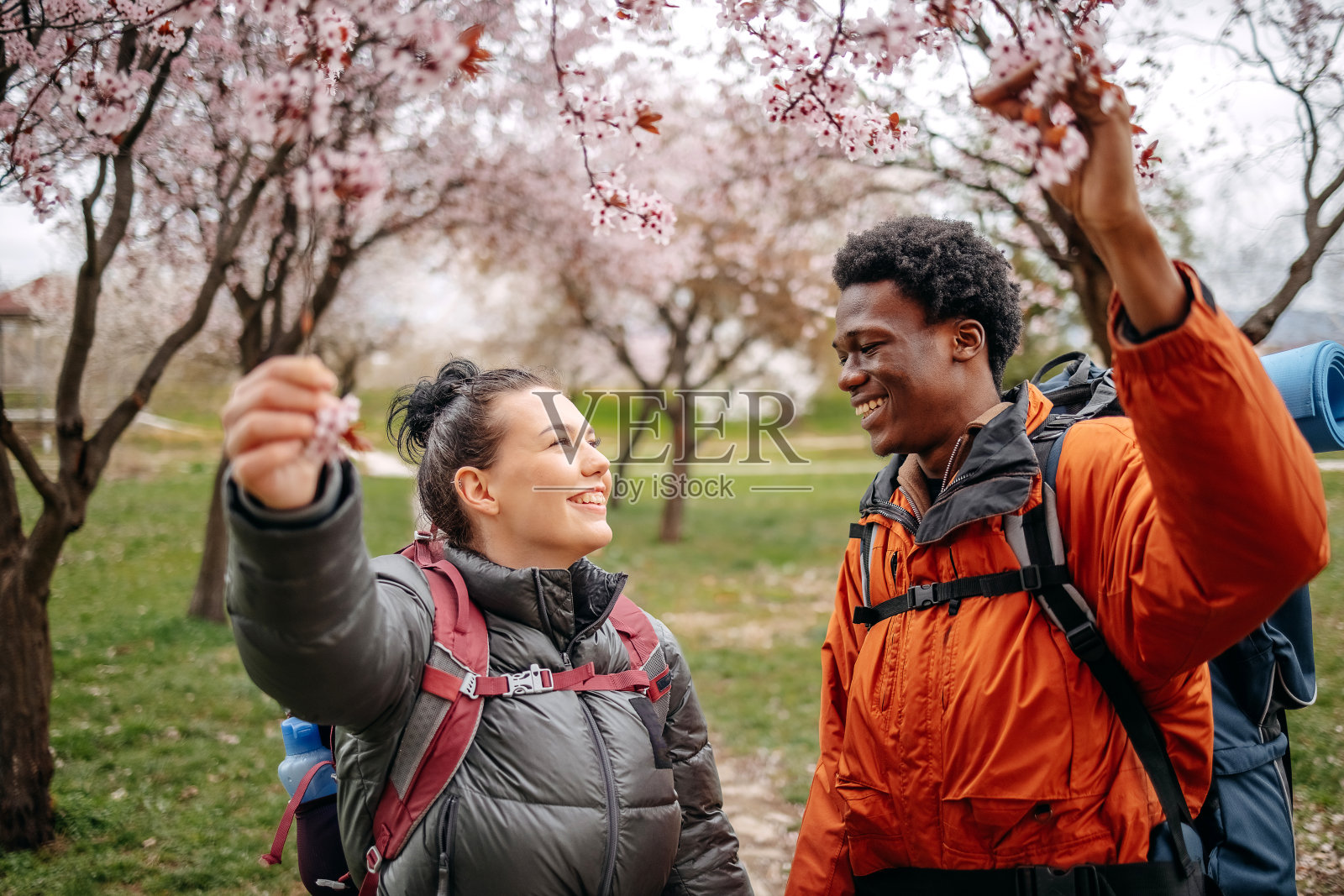 多种族夫妇背着背包在城市公园里享受春天的散步照片摄影图片