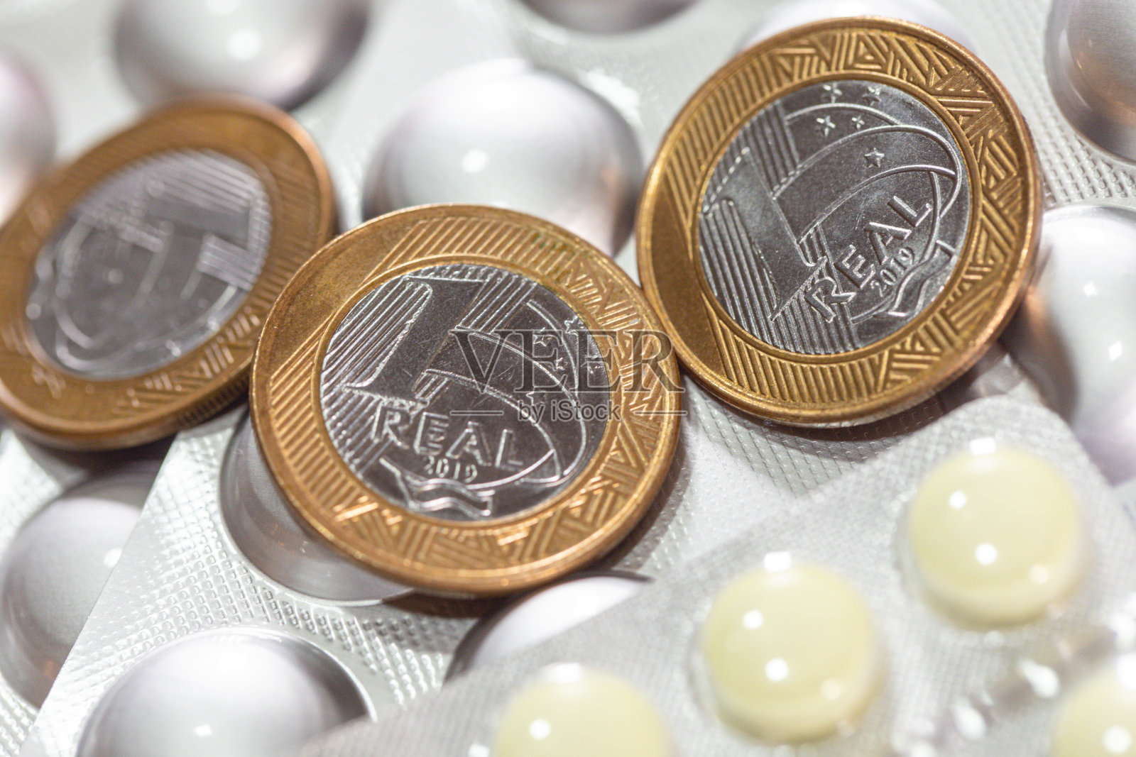 药品包装上的巴西硬币。药品和通货膨胀。照片摄影图片