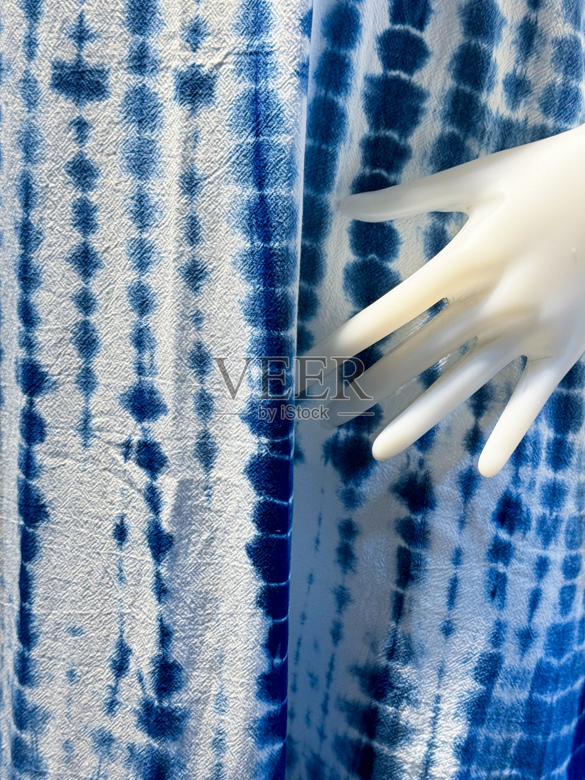 全帧图像定制，蓝色和白色领带染色牛仔背心面料，沙滩服冲浪服，塑料手的人体模型，重点在前景照片摄影图片