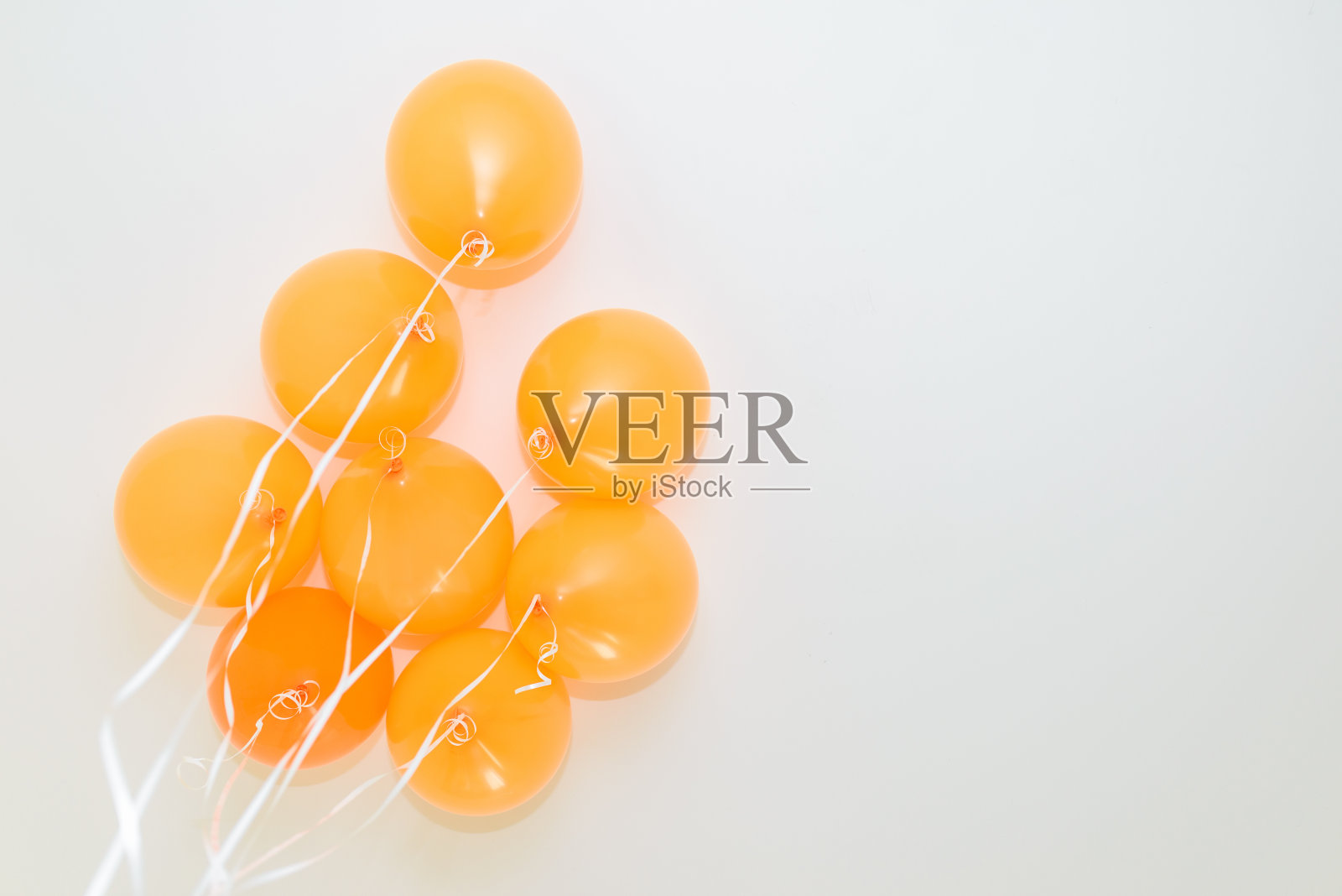 把橙色的气球束在白色的背景上。底部视图。照片摄影图片