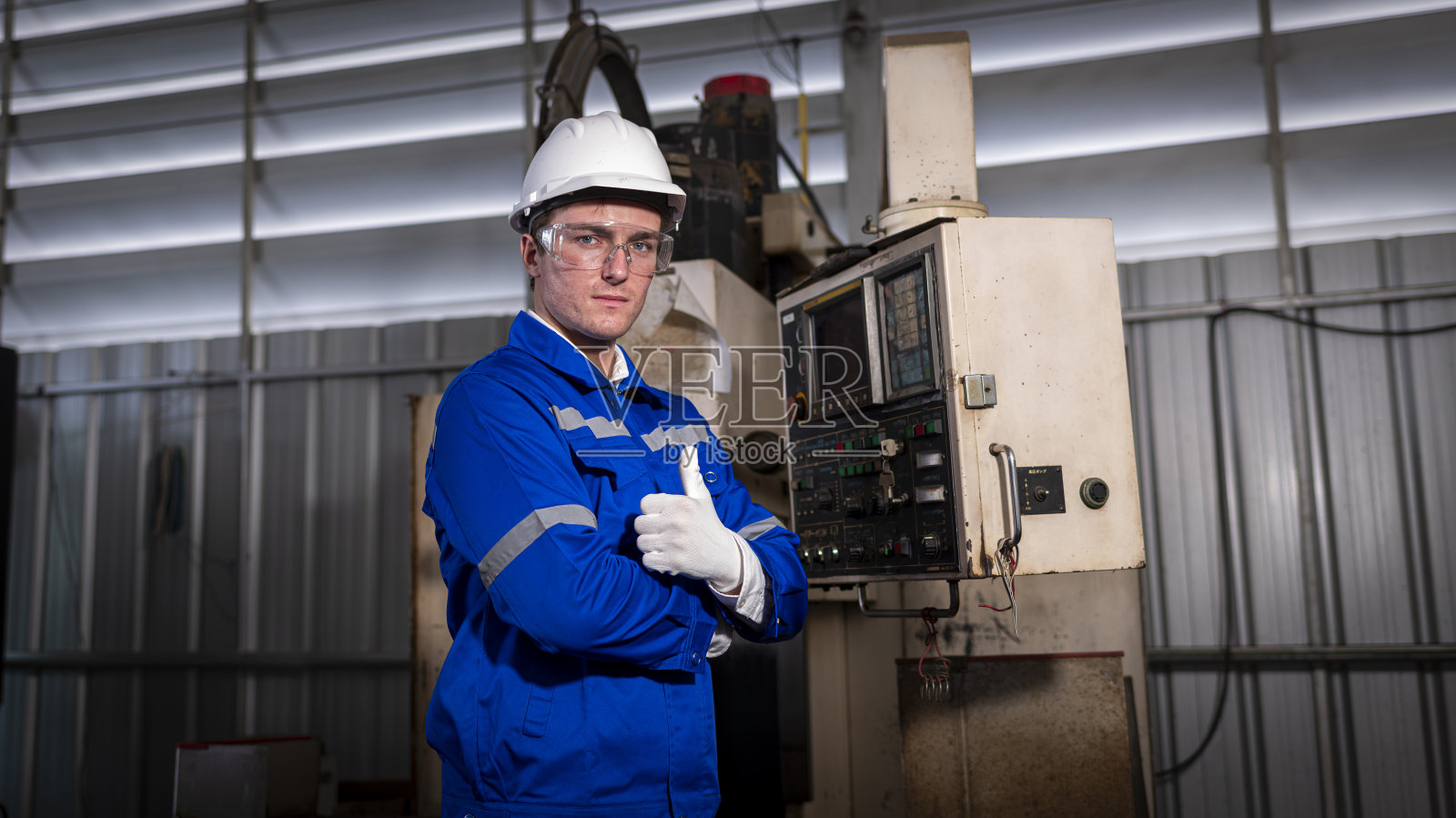 在工业工厂工作的工业工程师工人穿着安全制服控制操作计算机控制的车床磨床是金属制造业的概念。照片摄影图片