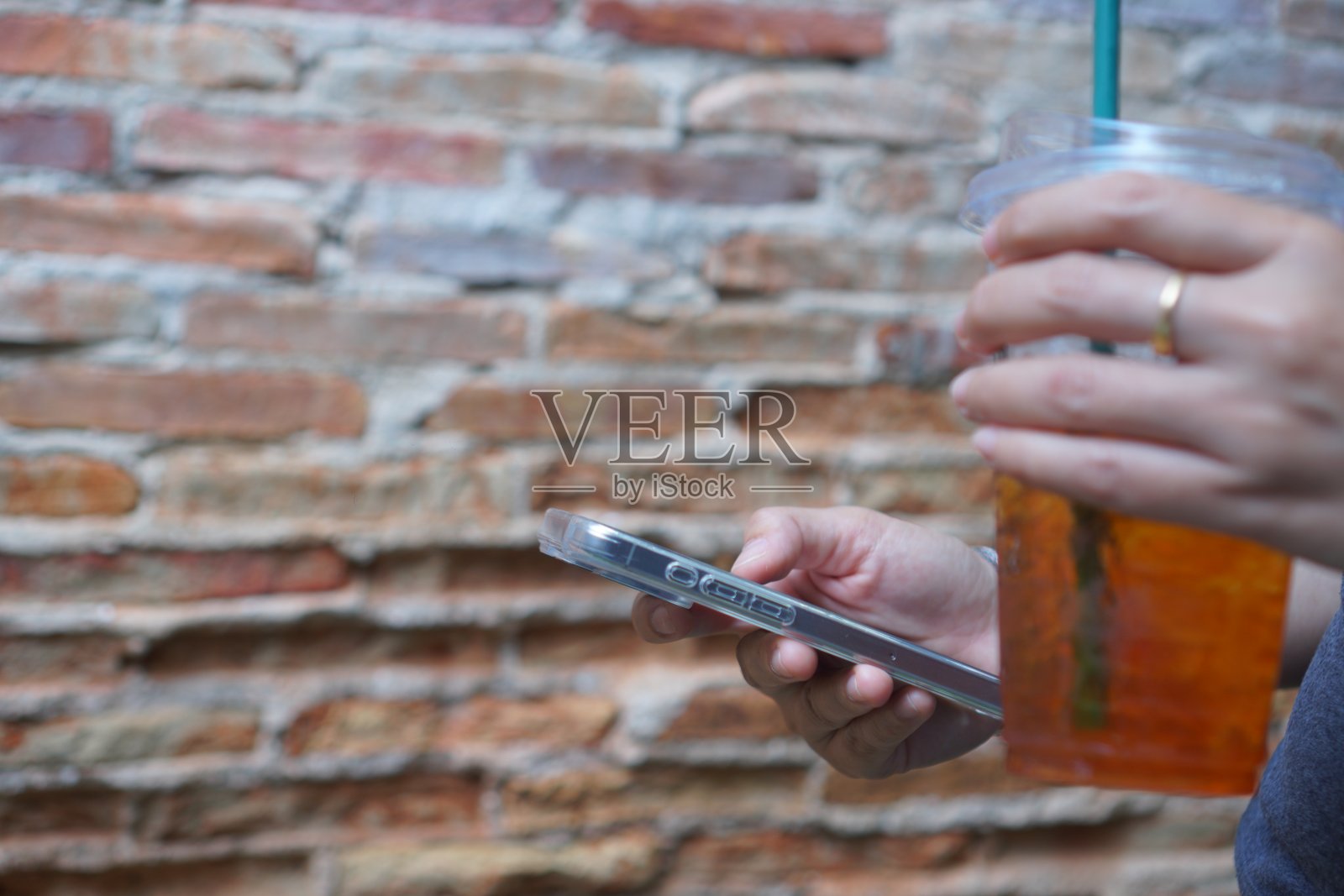 亚洲年轻女性穿着粉红色的衣服，用手机学习，在家里享受社交媒体。轻松生活理念照片摄影图片