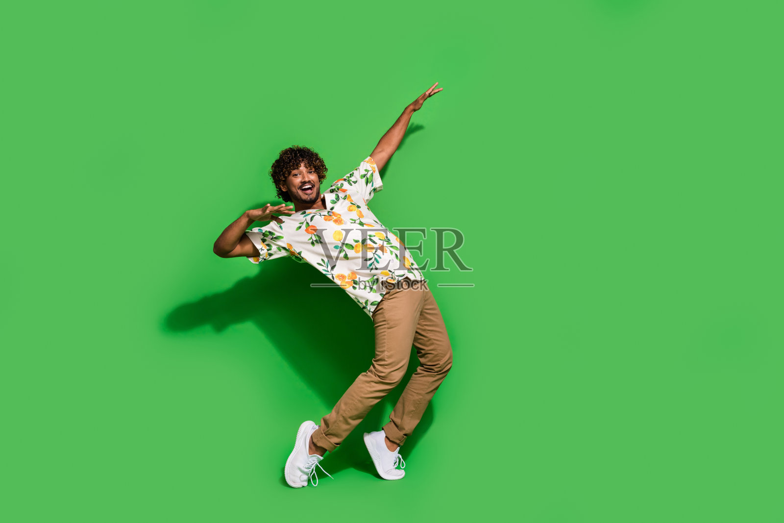 欢快的好心情拉丁家伙穿着印花衬衫跳舞迪斯科空的空间孤立的绿色背景的全身照片照片摄影图片