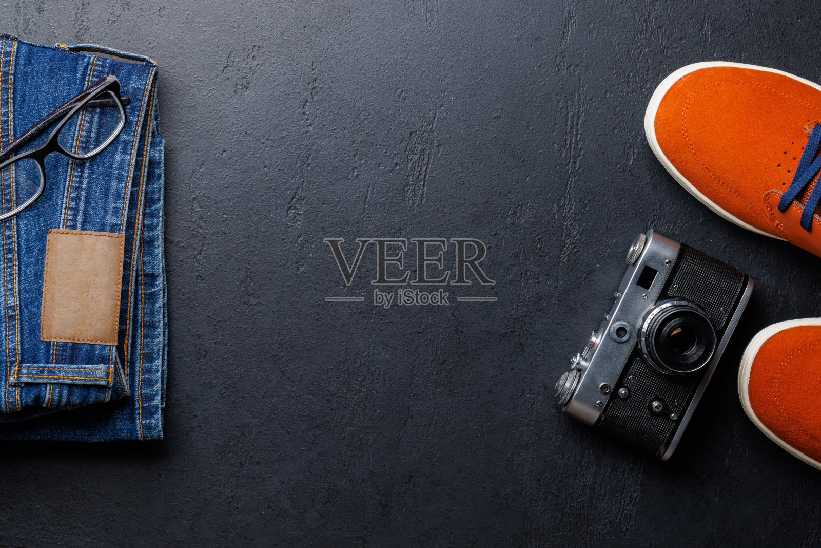 男士服装石材背景:牛仔裤，运动鞋，眼镜照片摄影图片