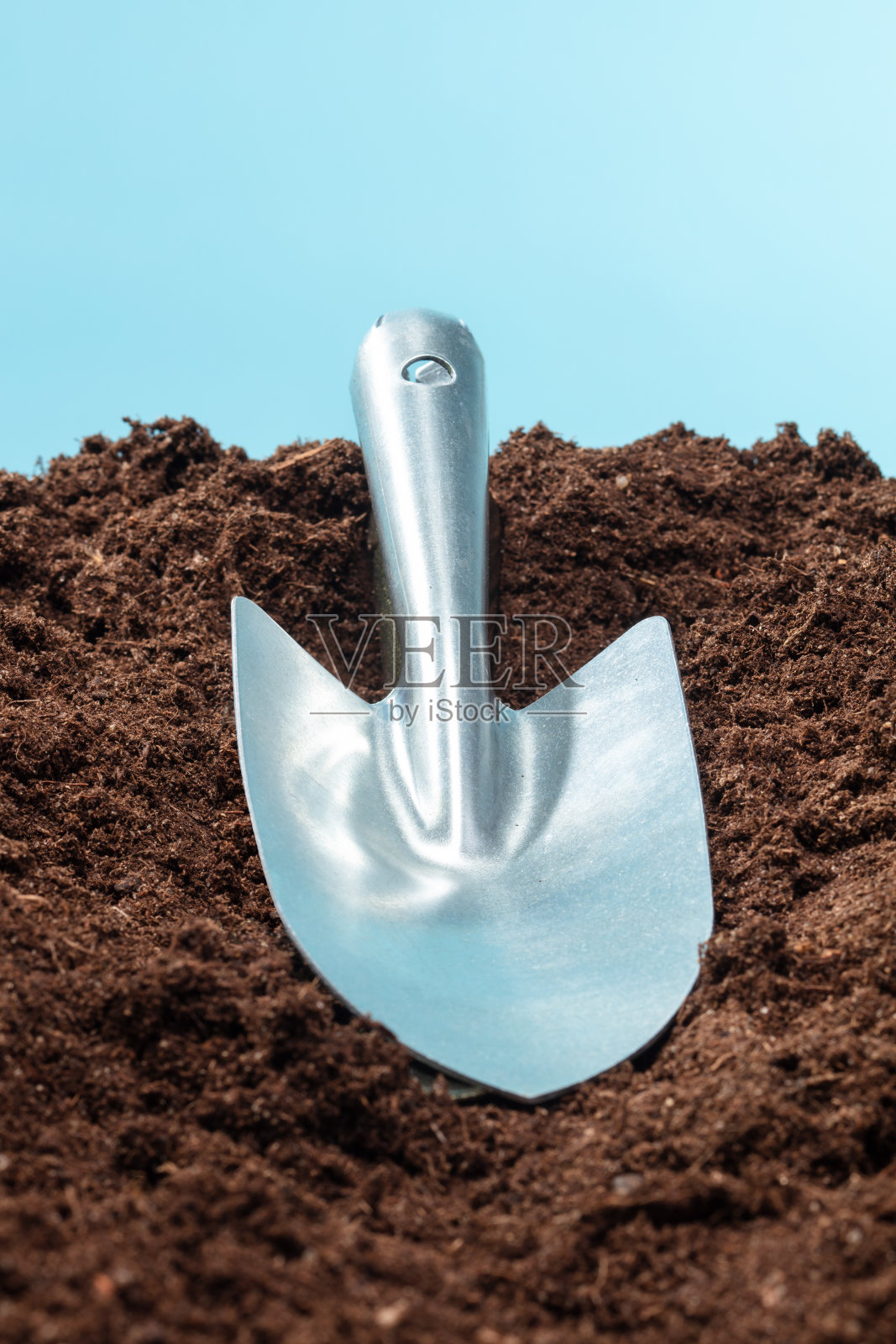 花园用铲子铲土。照片摄影图片