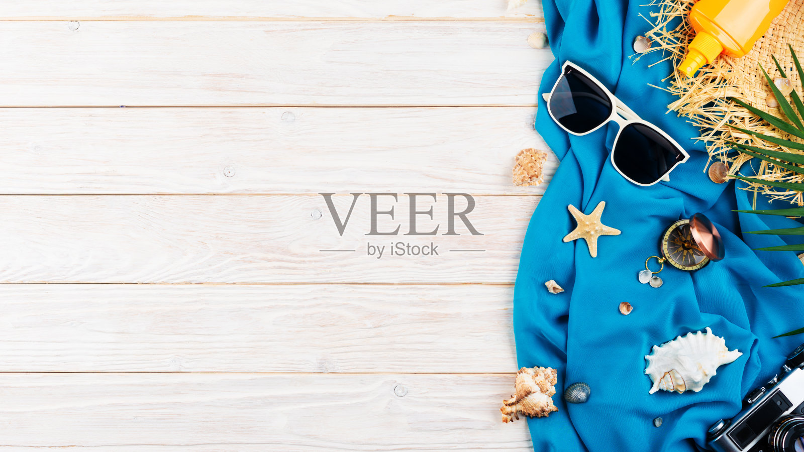 贝壳，海星，太阳镜，指南针，相机和草帽在蓝色的织物和白色的木板度假计划背景平躺与复制空间照片摄影图片